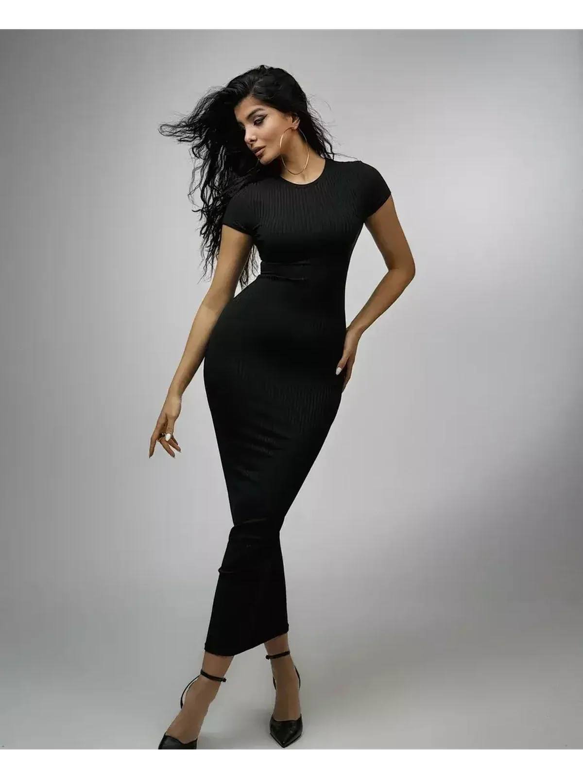 Sleek black Obsidian Maxi Dress in ribbed knit with short sleeves and crew neckline, showcasing a sculpted silhouette.