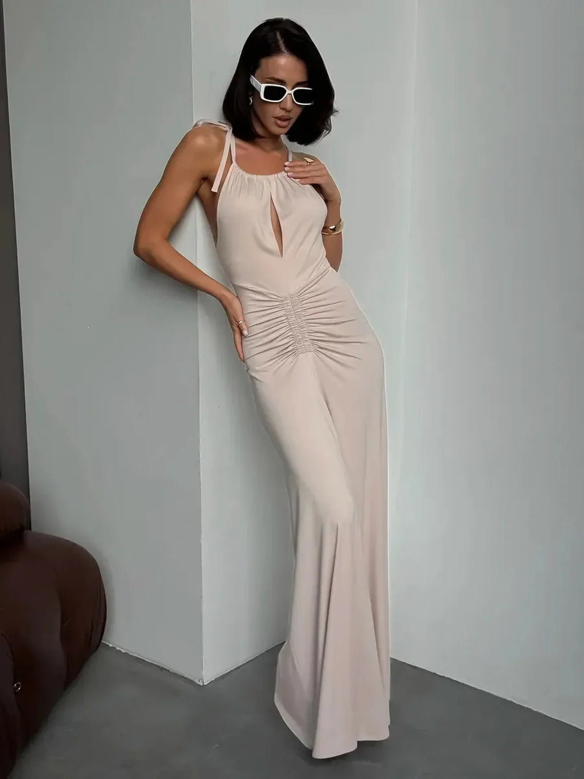 Model showcasing the Serene Curve Maxi Dress with halter neckline and ruched detailing in a soft neutral tone.