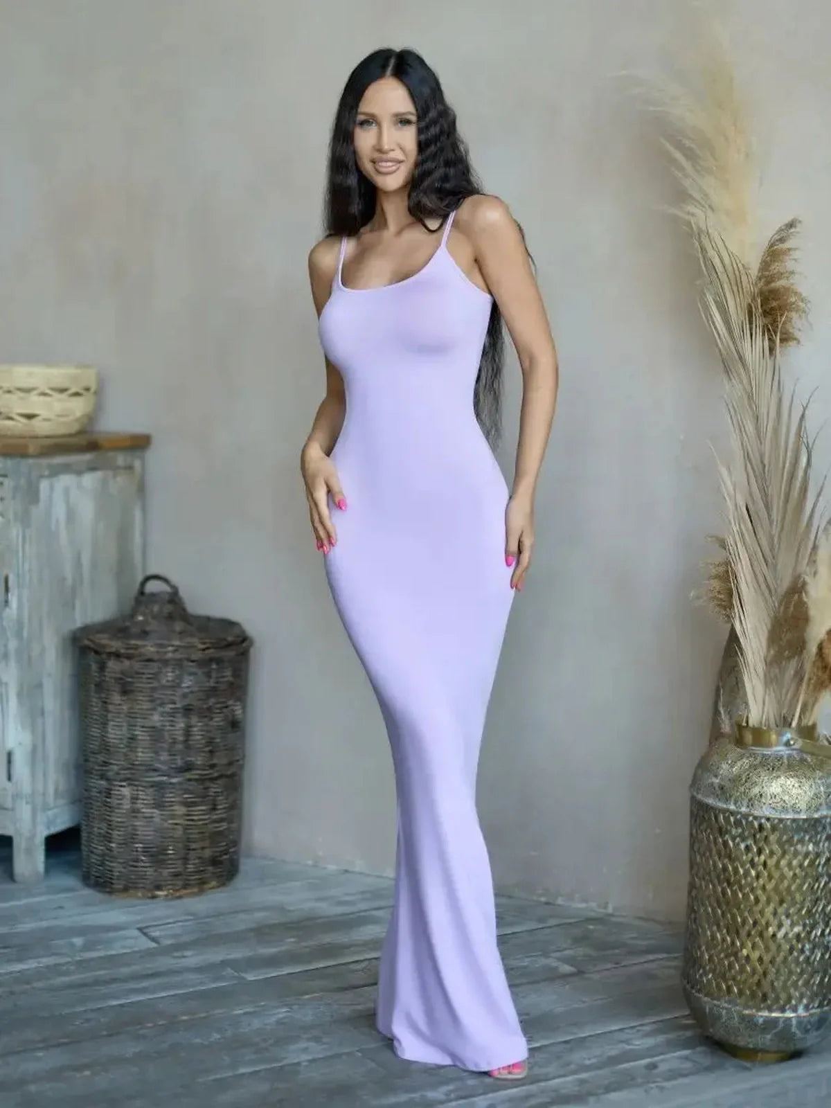 Model showcasing the Lilac Luxe Maxi Dress, a figure-hugging lavender gown with delicate spaghetti straps.