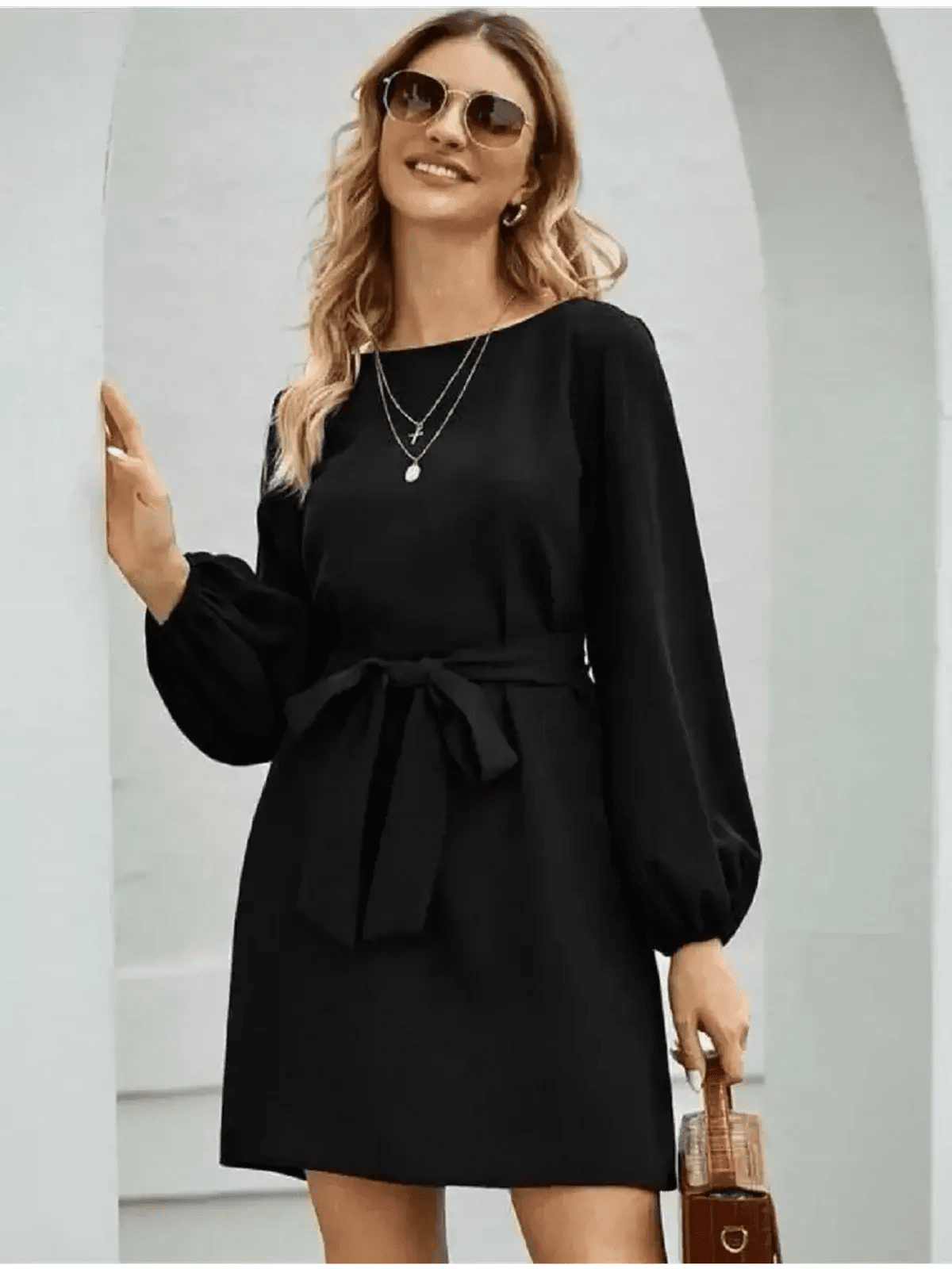 Model wearing a black mini dress with long sleeves and a self-tie belt, perfect for summer or cocktail events.