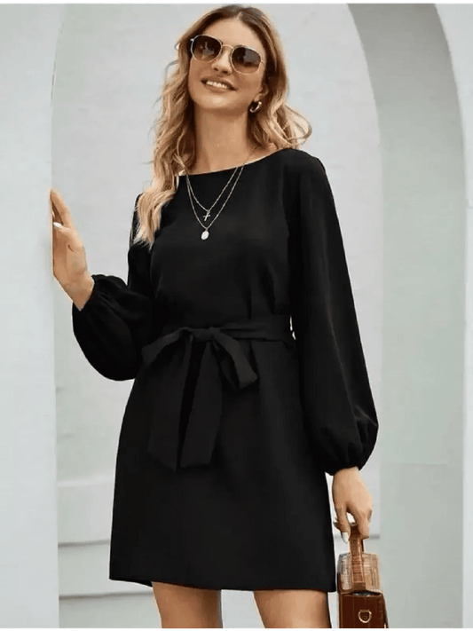 Model wearing a black mini dress with long sleeves and a self-tie belt, perfect for summer or cocktail events.