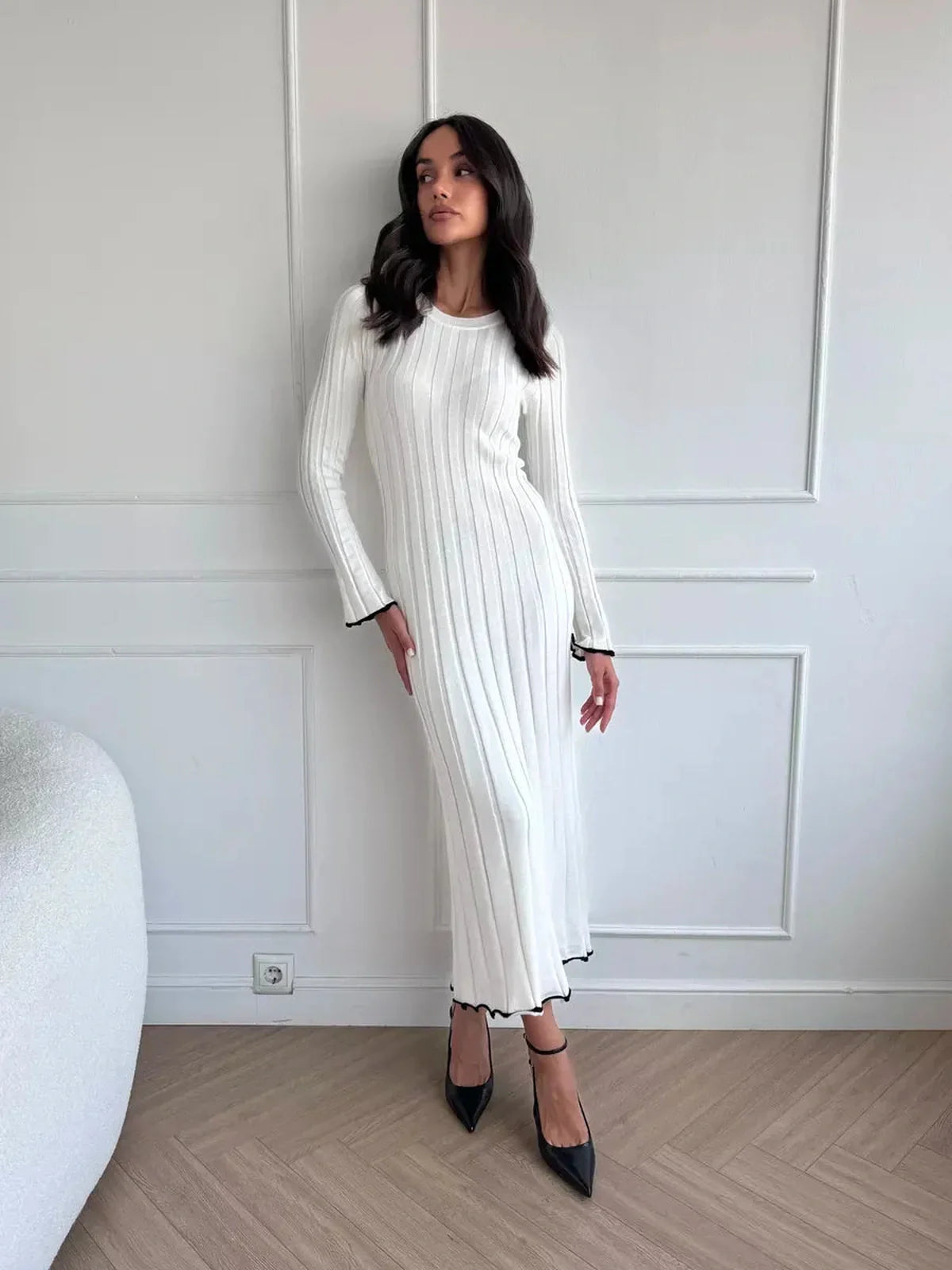 Model showcasing the Ivory Grace Maxi Dress featuring a sleek ribbed design and elegant ruffle trim for refined style.