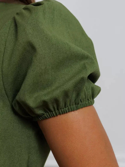 Detail view of olive green puff sleeve on the Olive Whisper Maxi Dress, showcasing elegant fabric and design.