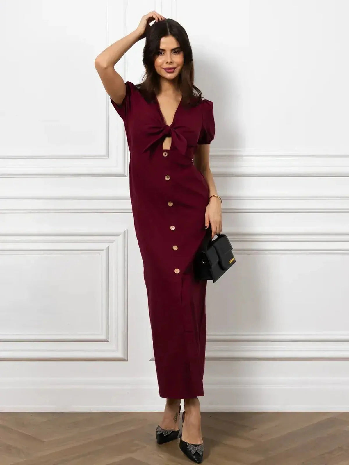 Model showcasing the elegant Maxi Dress Merlot Grace with front bow and button detail in rich burgundy.