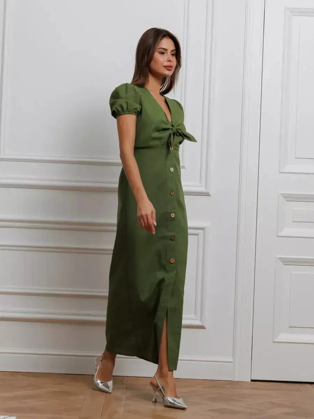 Model wearing Olive Whisper Maxi Dress with puff sleeves and tie front, showcasing earthy green elegance and stylish buttons.
