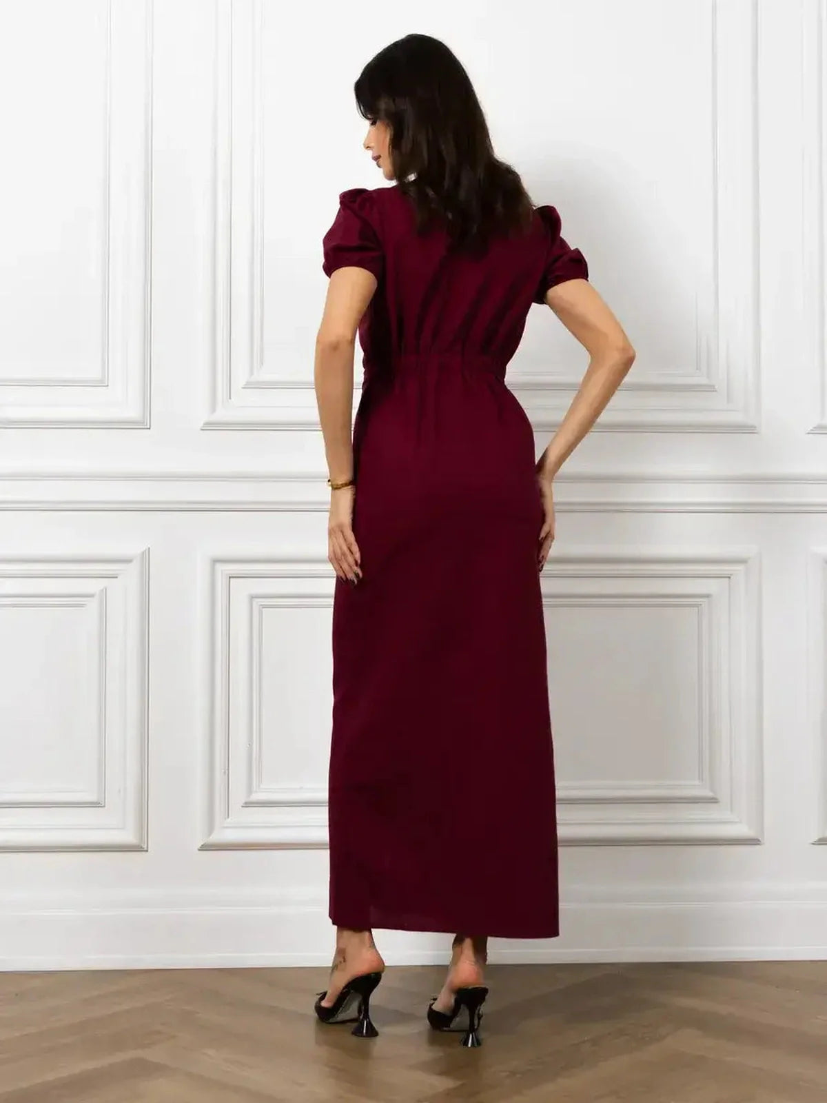 Back view of Maxi Dress Merlot Grace featuring a sleek silhouette, elasticated waist, and structured puff sleeves.
