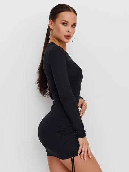 Side view of a woman in a black long sleeve midi dress featuring ruched sides and adjustable drawstrings.