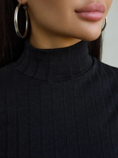Close-up of a high stand collar black ribbed dress, showcasing a chic look with hoop earrings.