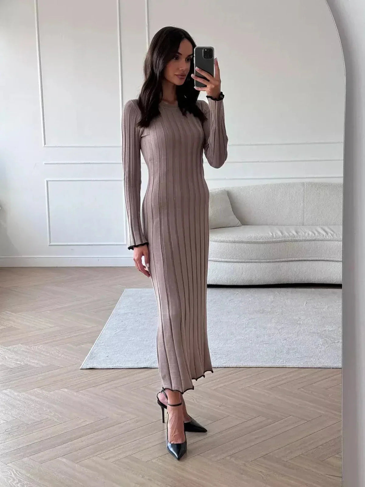 Model showcasing the Contour Maxi Dress in ribbed knit with a full-length silhouette and elegant ruffle hem.