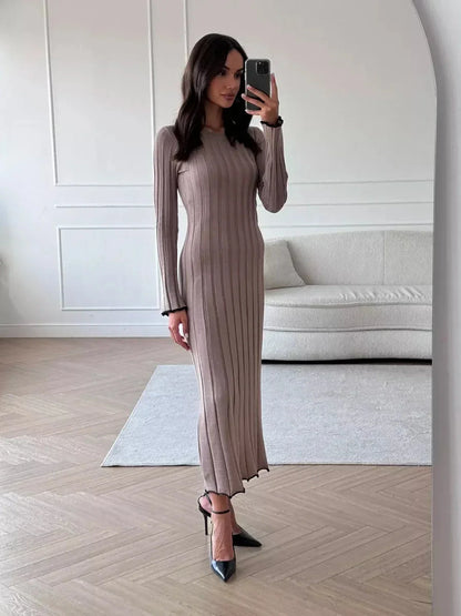 Model showcasing the Contour Maxi Dress in ribbed knit with a full-length silhouette and elegant ruffle hem.