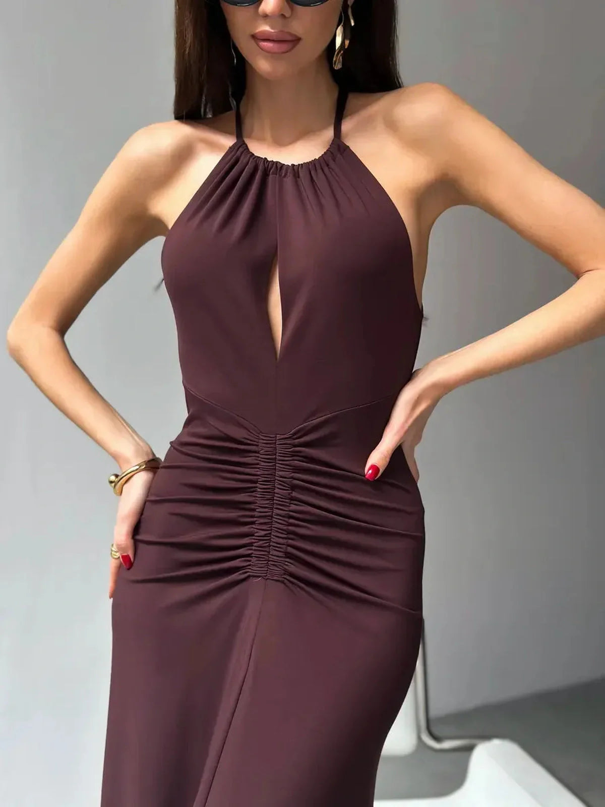 Model showcasing the Maxi Dress Sienna with halter neckline and figure-defining ruching in rich sienna shade.