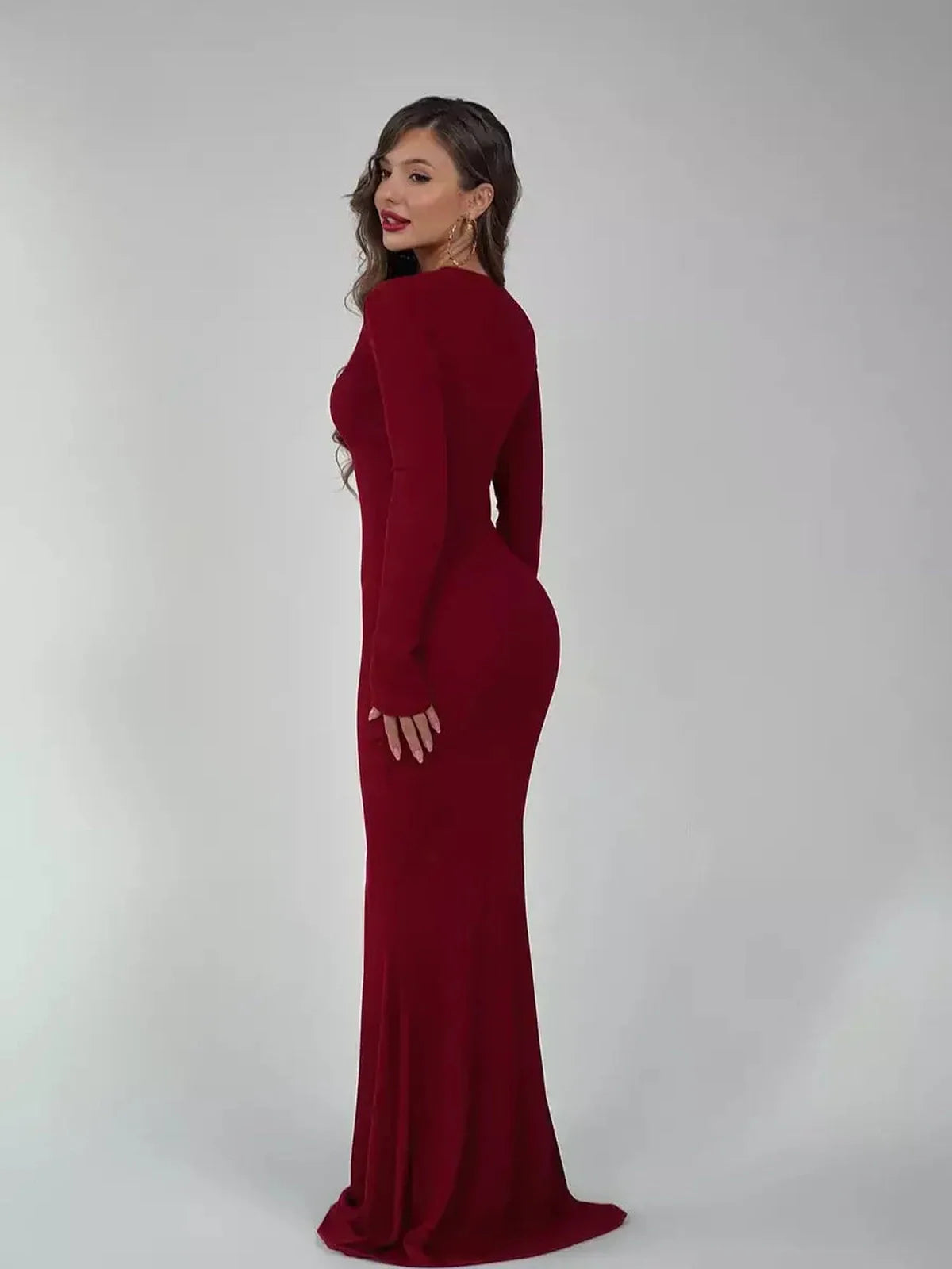 Elegant burgundy Velvet Ember Maxi Dress showcased on model's side, highlighting its sleek silhouette and luxurious fabric.