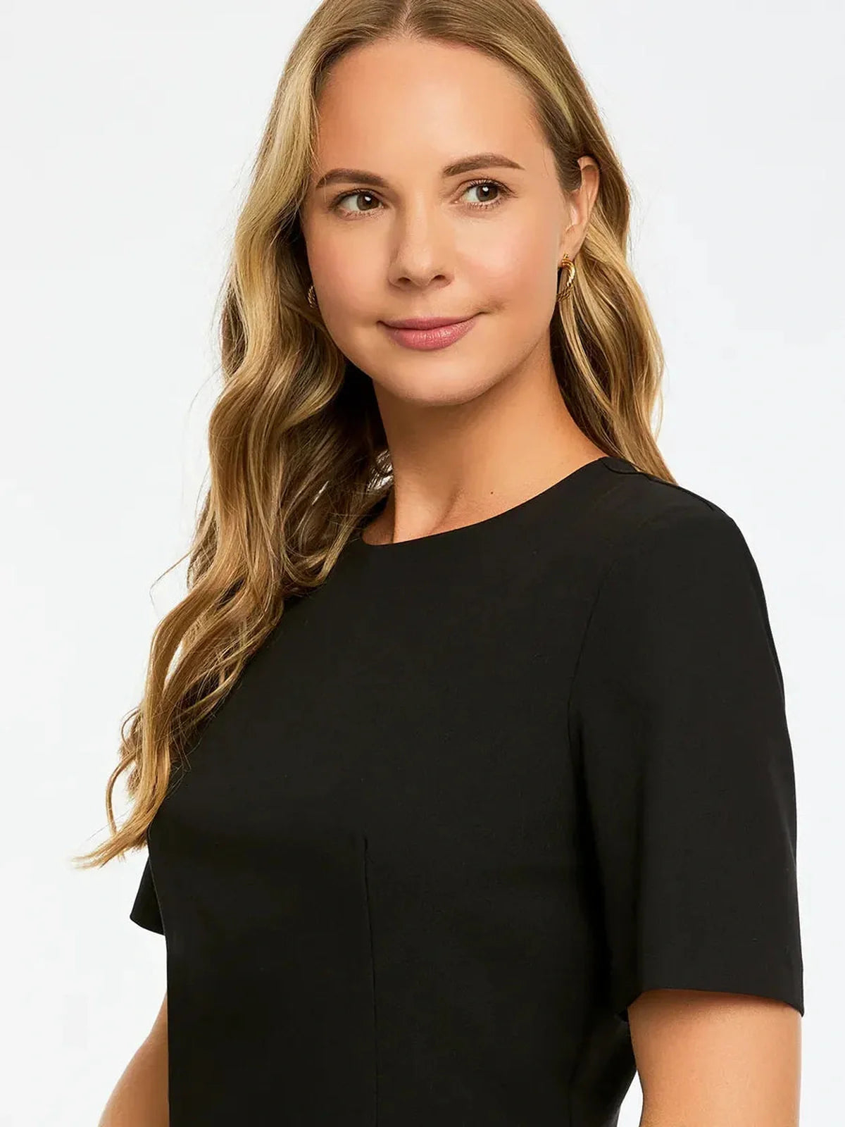 Close-up of a woman wearing a stylish black dress, showcasing elegant design and flattering fit.