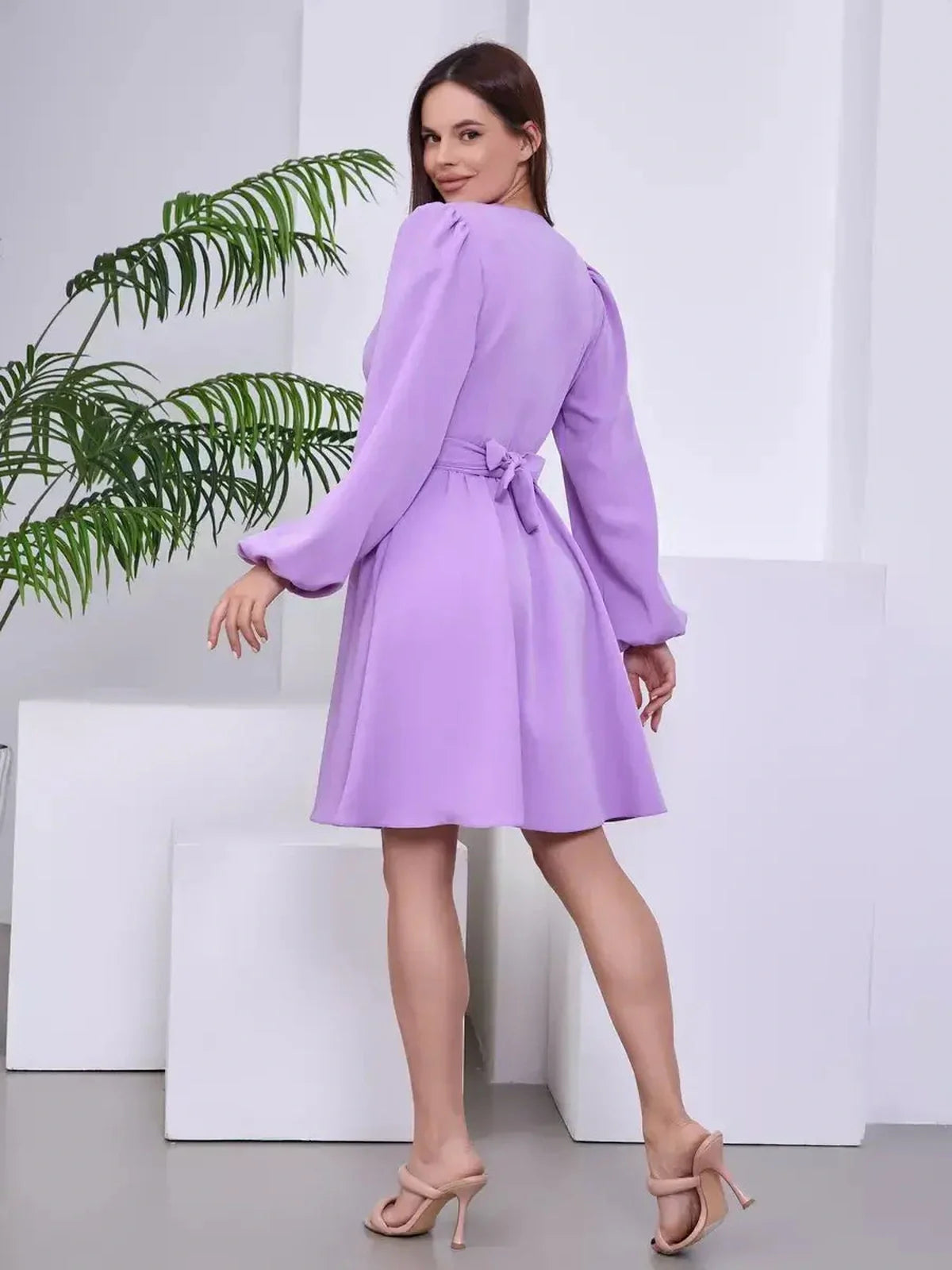 Model showcasing the Lilac Whisper long sleeve dress, highlighting its elegant wrap design and soft lavender color.