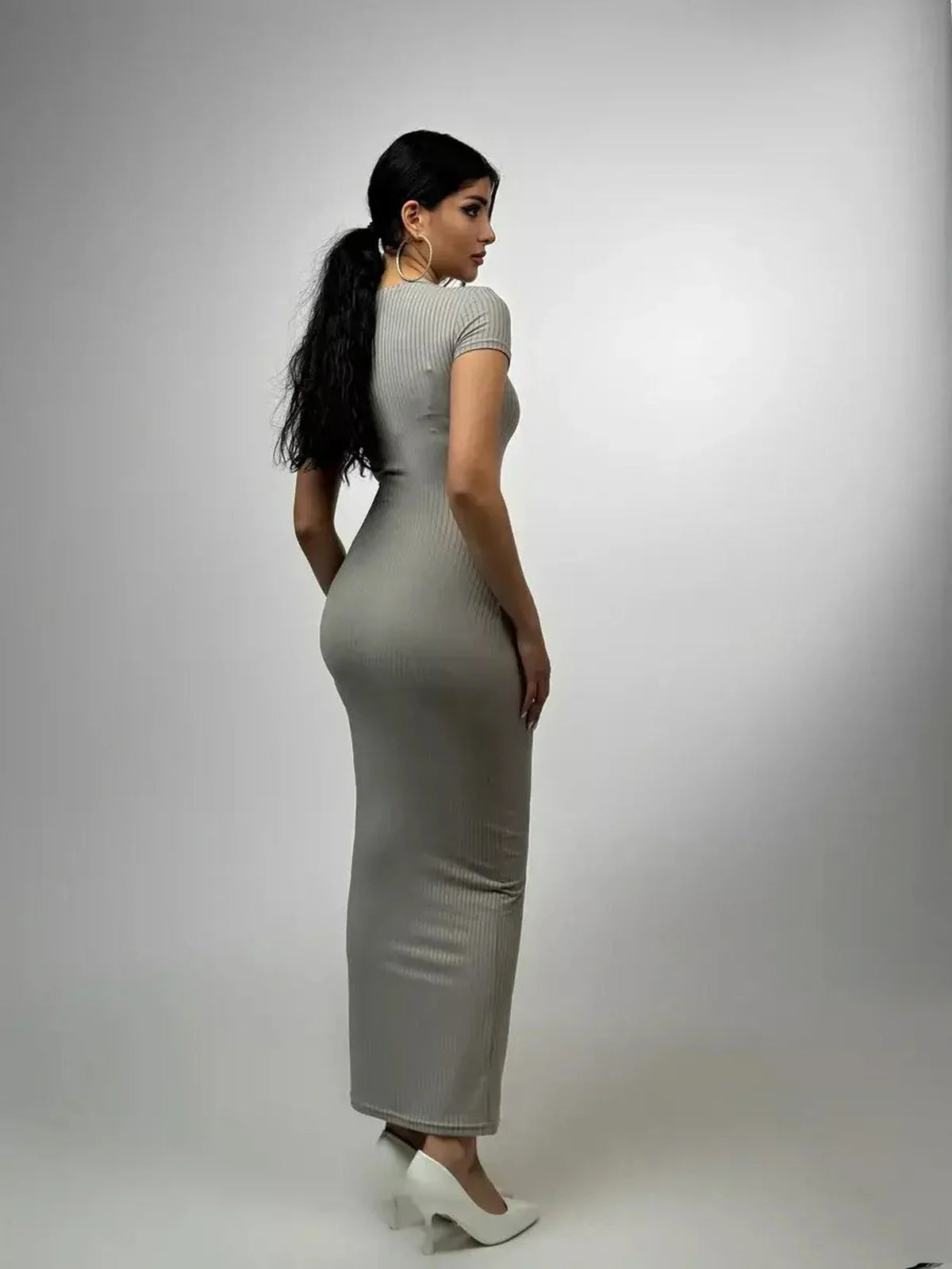 Model showcasing the Sculpted Grace Maxi Dress in gray, highlighting its sleek ribbed silhouette and elegant fit.