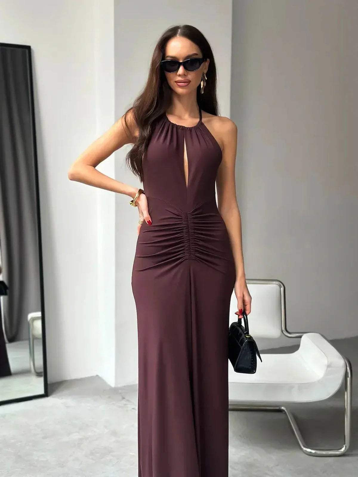Model wearing the Maxi Dress Sienna, showcasing its halter neckline, ruched details, and elegant sienna hue.