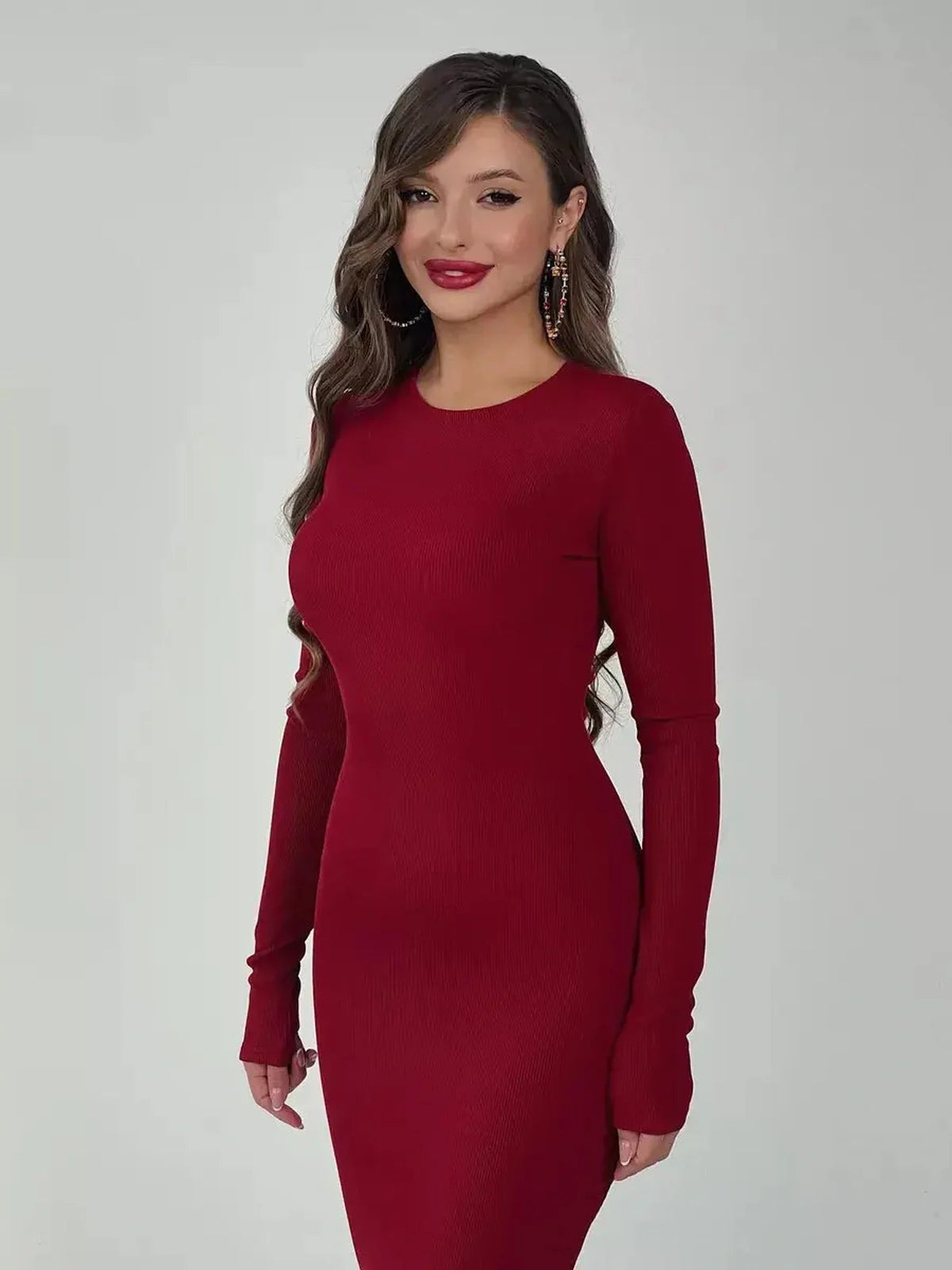 Model showcasing a burgundy long sleeve Velvet Ember Maxi Dress, emphasizing its elegant silhouette and luxe stretch fabric.