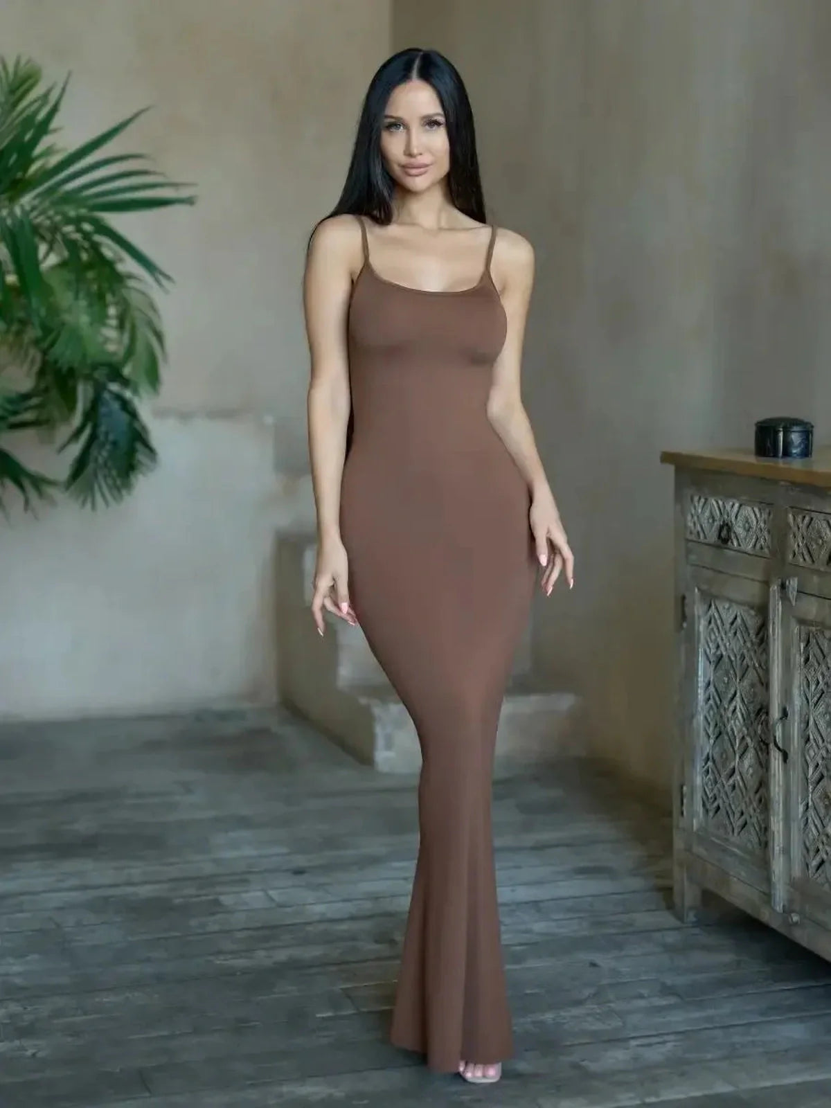 Model showcasing the Cocoa Curve Maxi Dress in warm chocolate hue, highlighting its sleek, minimalist design.