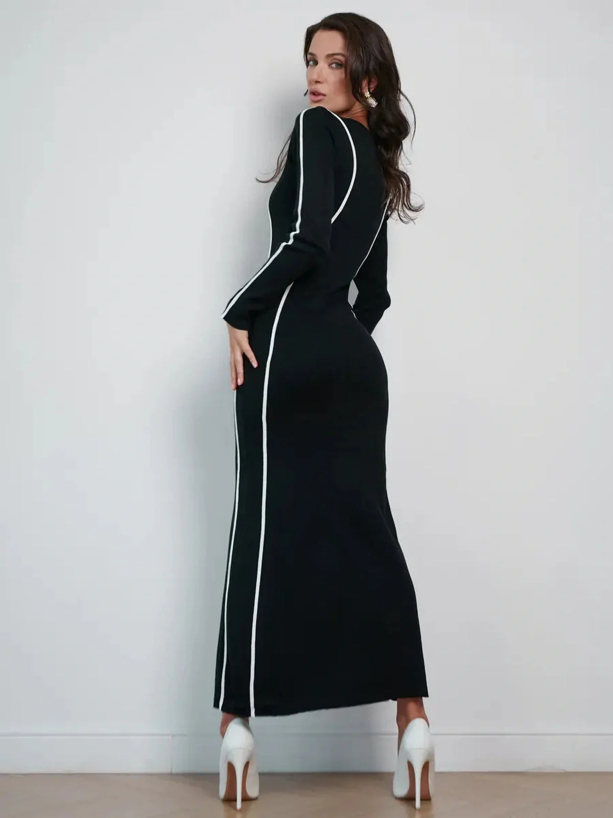 Model showcasing the Midnight Curve Maxi Dress, featuring a sculpting silhouette and elegant white piping on a black background.