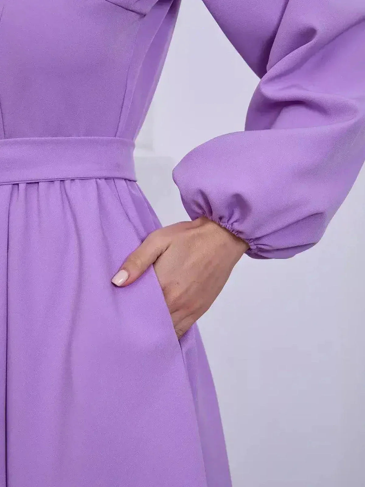 Close-up of the Lilac Whisper long sleeve dress showcasing elegant fabric and tailored waist with a matching belt.