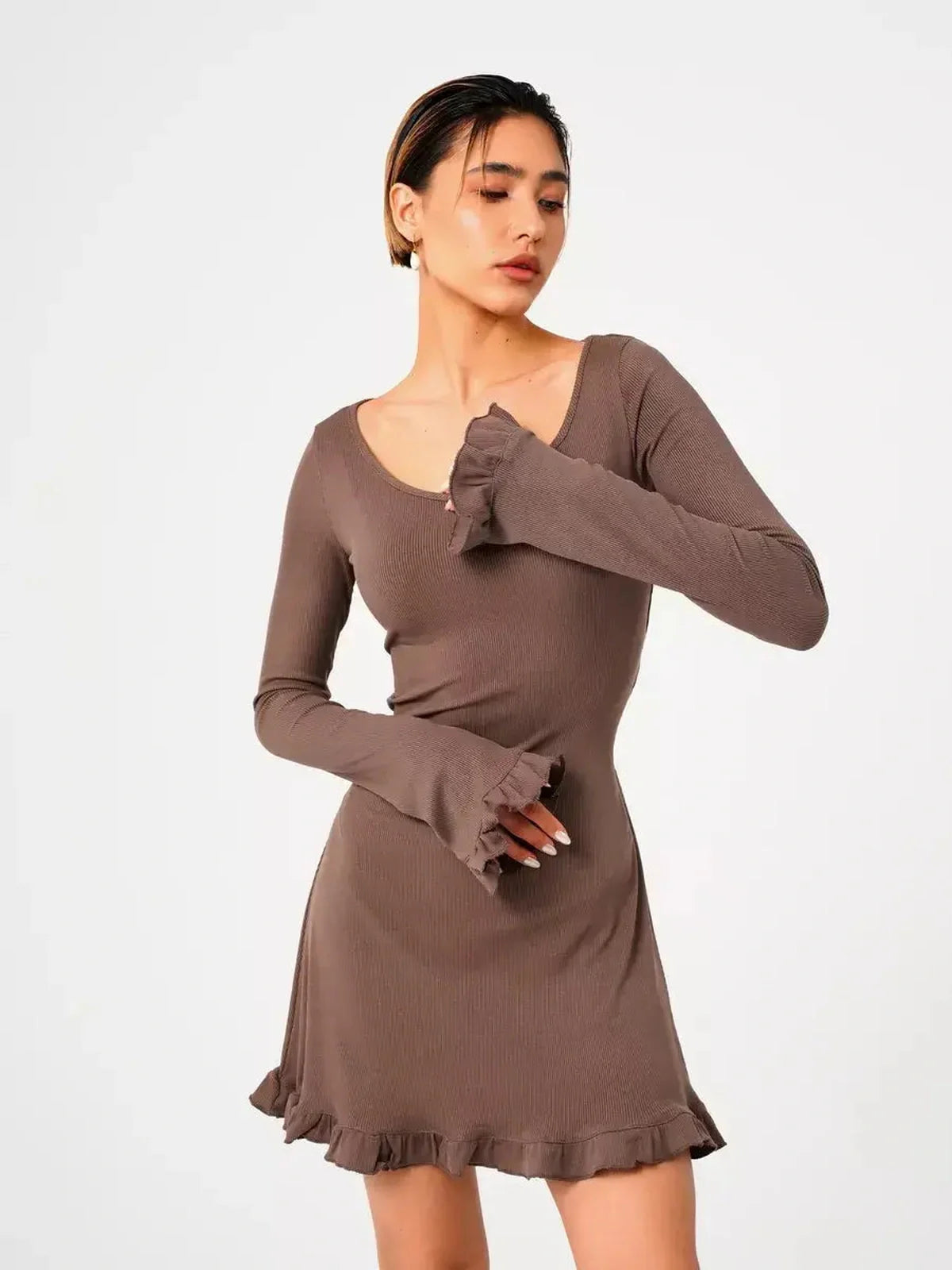 Model wearing the Mocha Flare ribbed knit mini dress with flared cuffs and romantic ruffled trim.