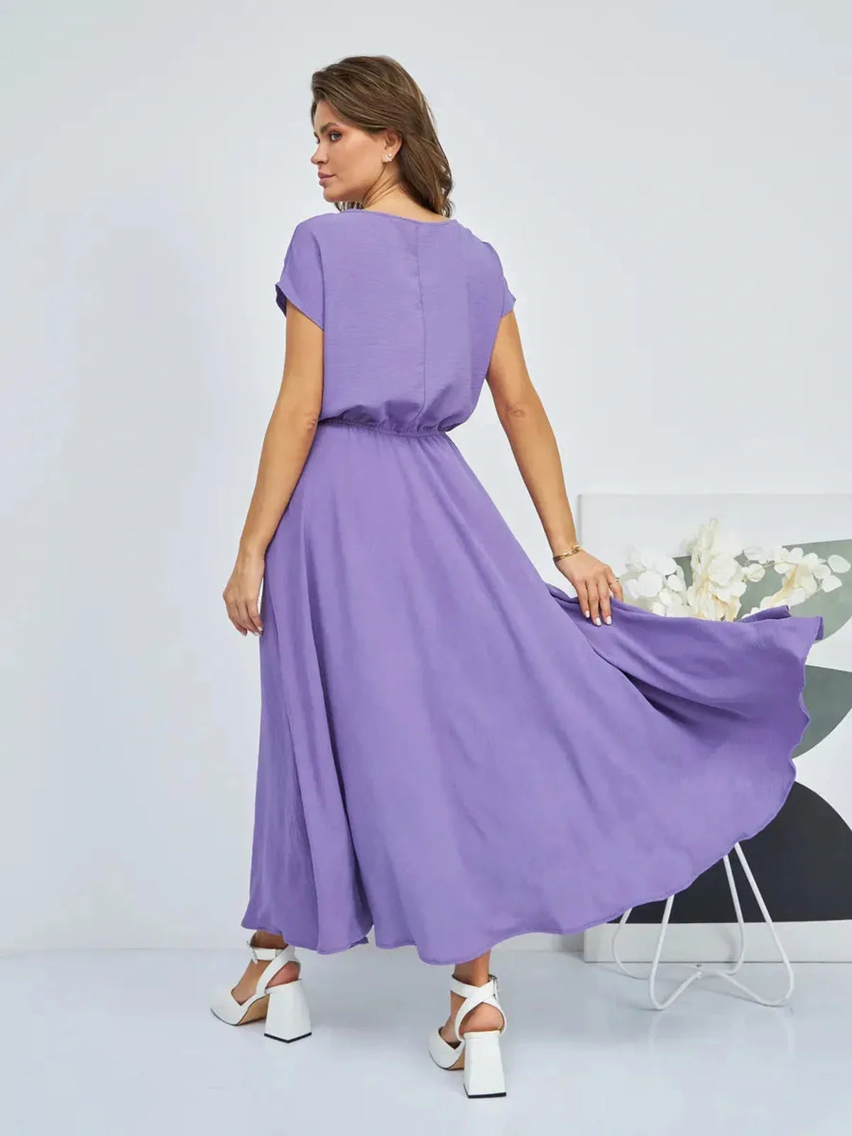 Woman wearing a flowing lavender maxi dress with gathered waist, perfect for summer elegance and comfort.