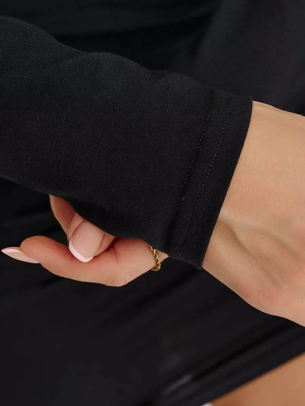 Close-up of long sleeve detail on a black midi dress, showcasing breathable fabric and fitted design.