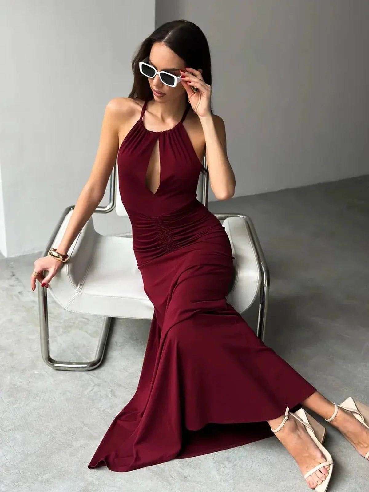 Model wearing burgundy Maxi Dress Élan with draped halter neckline and ruched waist, exuding elegance and sophistication.