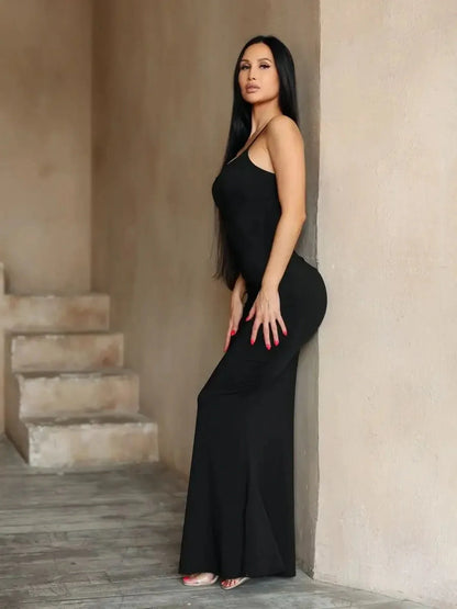 Woman wearing a sleek black Sculpted Grace Maxi Dress, highlighting elegance and sensuality in a minimalist style.