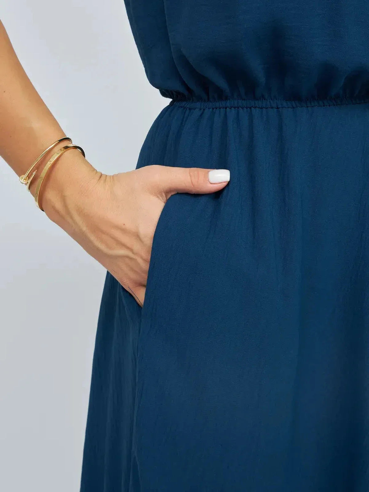 Close-up of a woman’s hand in the pocket of a navy Verona Maxi Dress, showcasing its lightweight summer elegance.