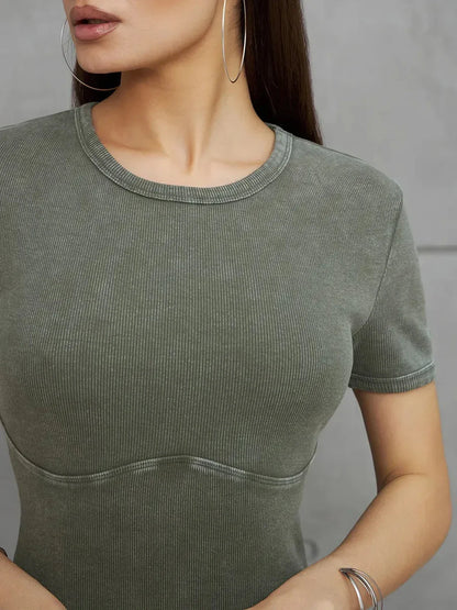 Close-up of a woman wearing a khaki green ribbed cotton dress, showcasing minimalist style and fitted silhouette.