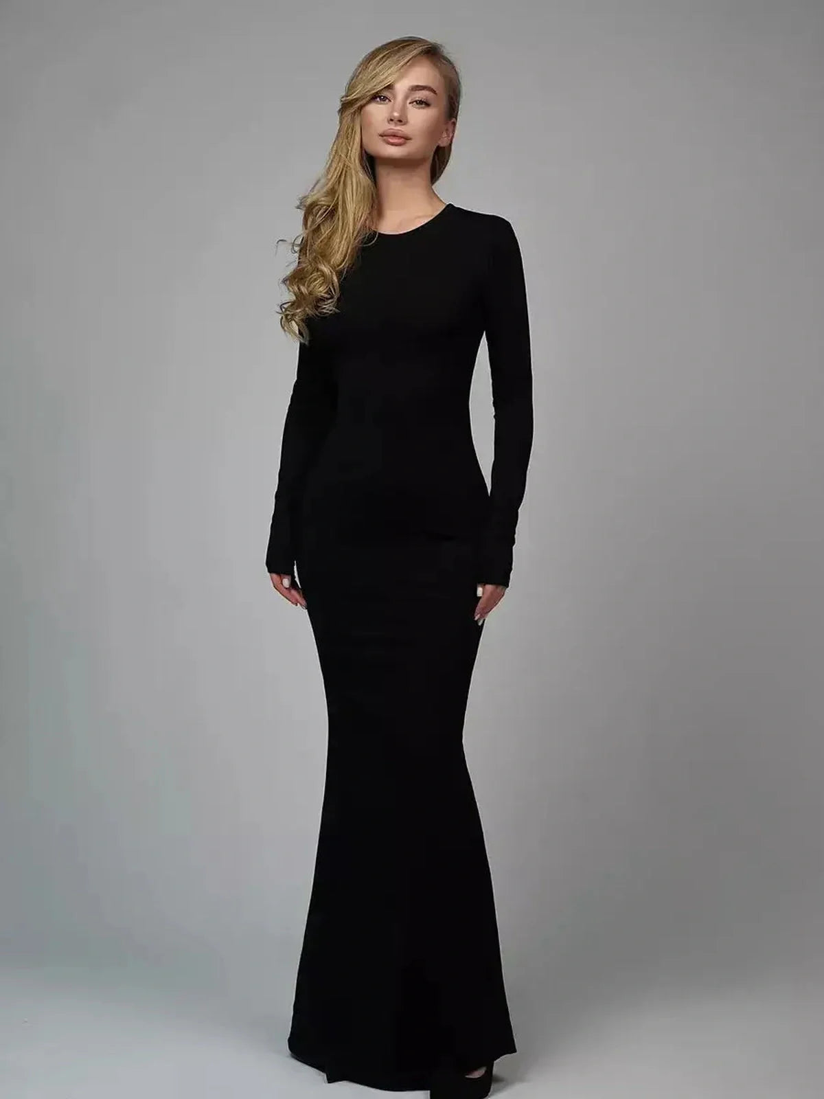 Sculpted Elegance Maxi Dress in black, showcasing its long sleeve design and seamless silhouette, emphasizing body contour.