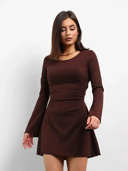 Model wearing a Cocoa Laced mini dress in rich chocolate brown, featuring long sleeves and a flared hem.