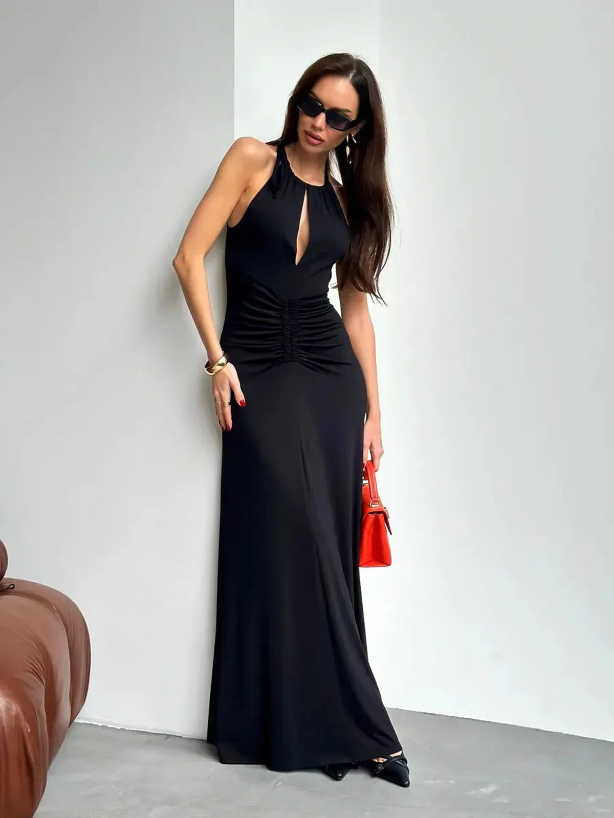Elegant black Maxi Dress Obsidian featuring ruched halter design, front slit, and stylish accessories.