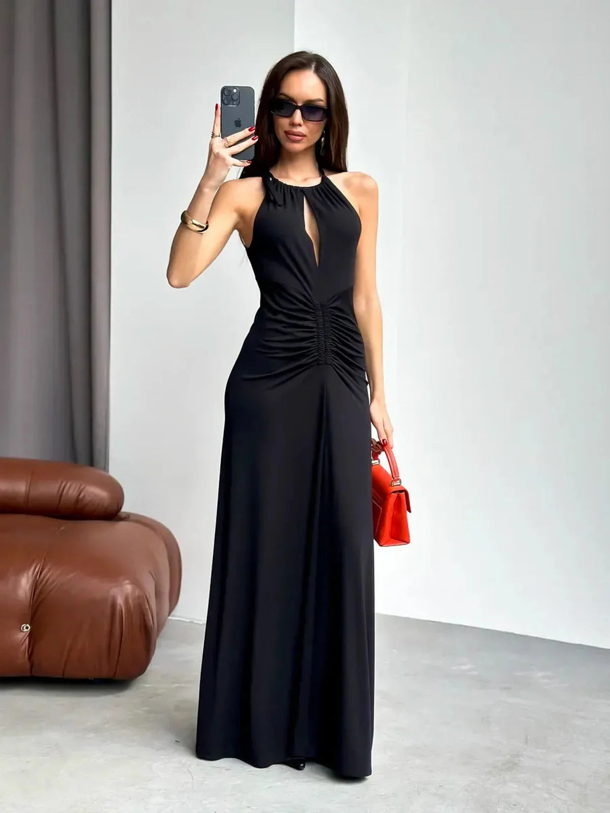 Model showcasing the elegant black Maxi Dress Obsidian with halter design and stylish front slit.