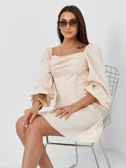 Beige mini dress, Lace Muse, with structured bodice and stylish puff sleeves, worn by a model in sunglasses.