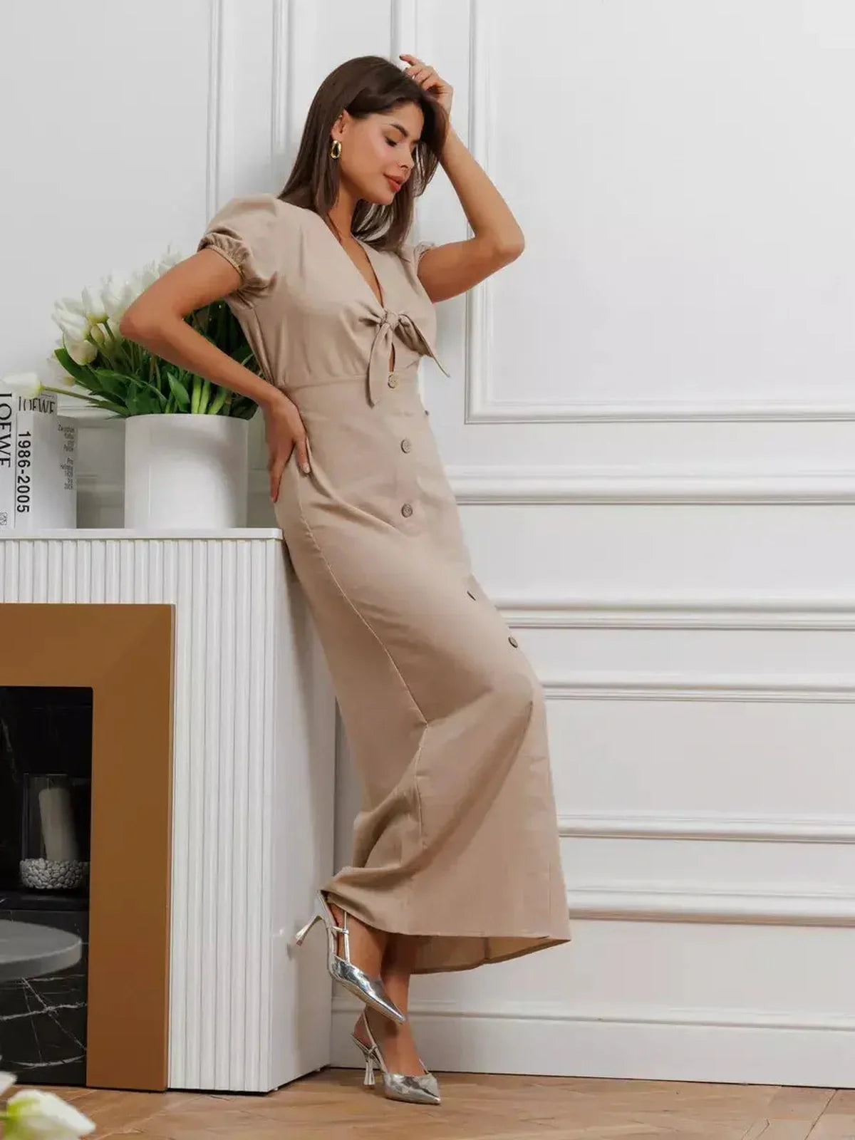 Woman in Serene Bond Maxi Dress with puff sleeves, waist tie, button detail, showcasing elegance in a neutral hue.