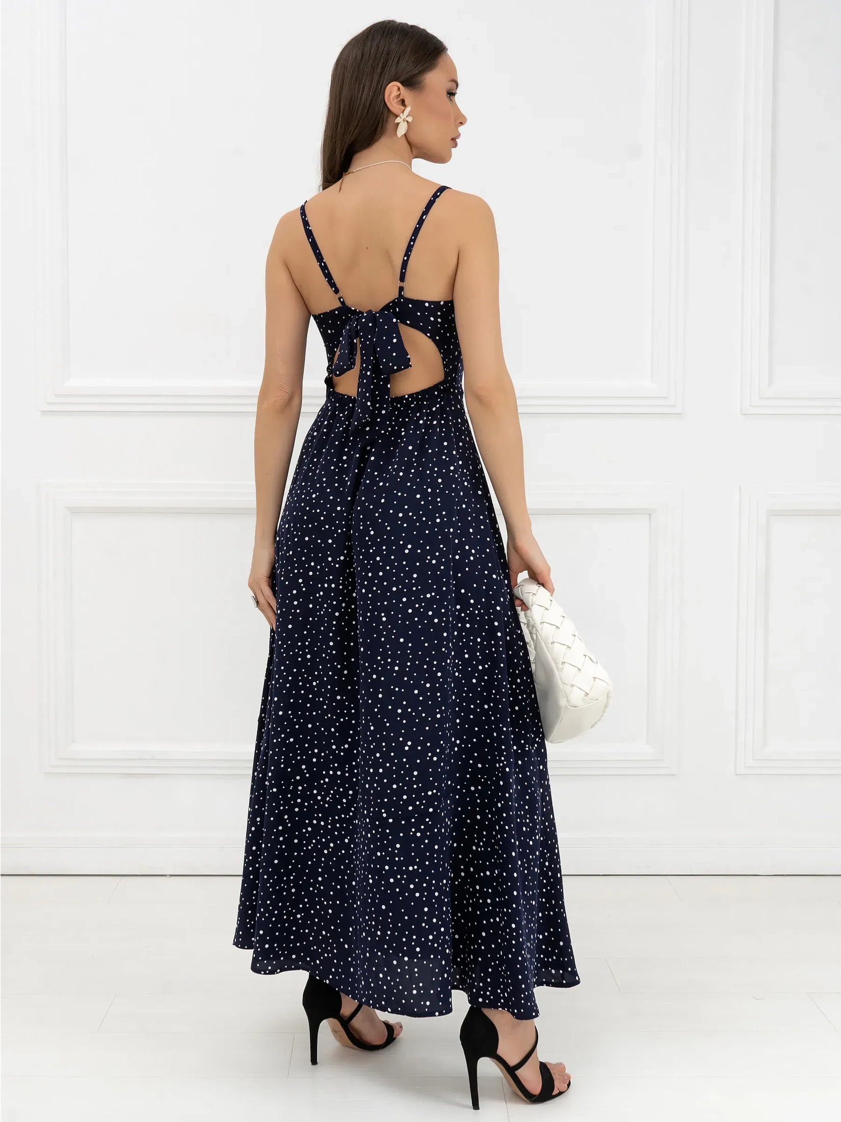 Back view of Noir Dots Maxi Dress showcasing tie details, micro-polka dots, and a flowing silhouette.