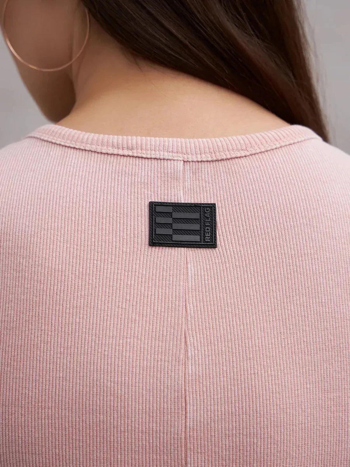 Close-up of the back of the Blush Curve Maxi Dress revealing a branded patch on a soft pink fabric.