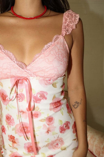 Close-up of a floral rose print maxi dress with pink lace straps, perfect for summer or special occasions.