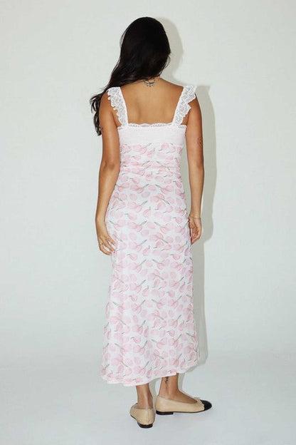 Back view of a woman in a pink floral maxi dress with lace straps, perfect for summer occasions.