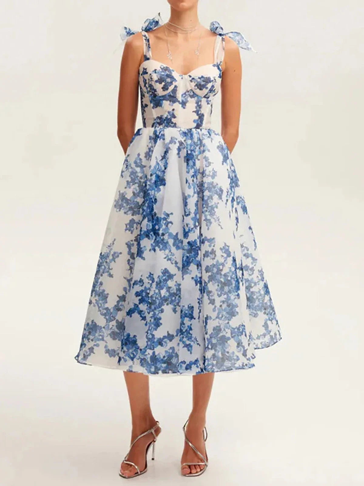 Floral midi dress with blue print and shoulder bows, perfect for weddings and summer occasions.