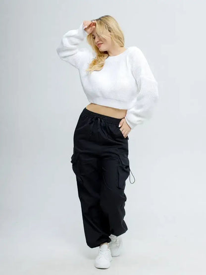 Model wearing Alba Pullover by Lauven, a lightweight knit in soft white with oversized cropped design.