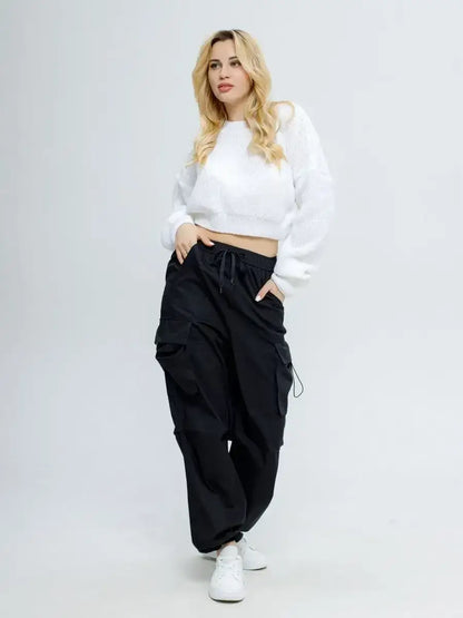 Alba Pullover by Lauven in soft white worn with black cargo pants for a stylish spring look.