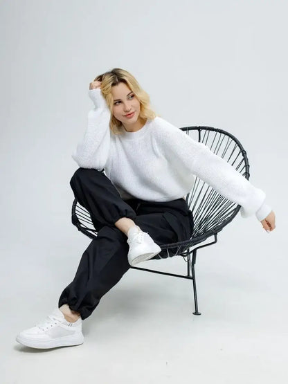 Alba Pullover by Lauven in soft white, styled with black pants and white sneakers, showcasing versatile spring fashion.