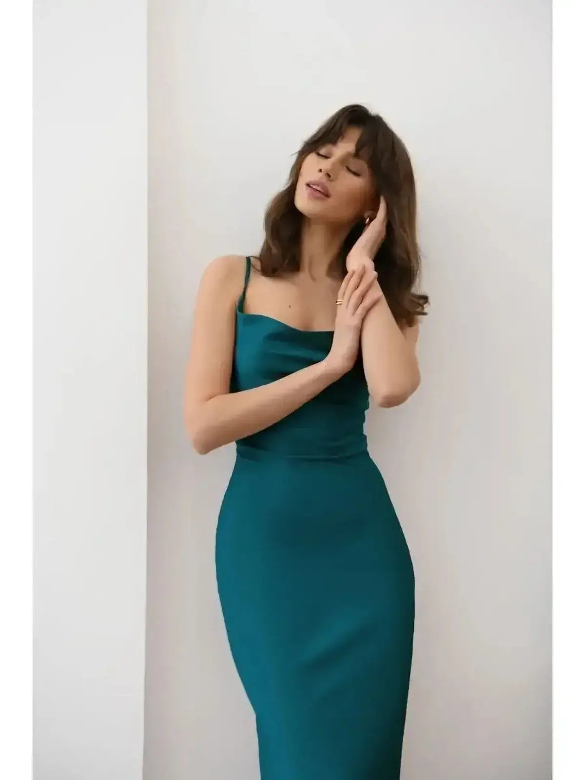 Model wearing Allure Midi Dress in rich emerald hue, showcasing sleek silhouette and satin shine, perfect for elegant occasions.