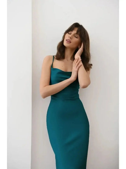 Model wearing Allure Midi Dress in rich emerald hue, showcasing sleek silhouette and satin shine, perfect for elegant occasions.