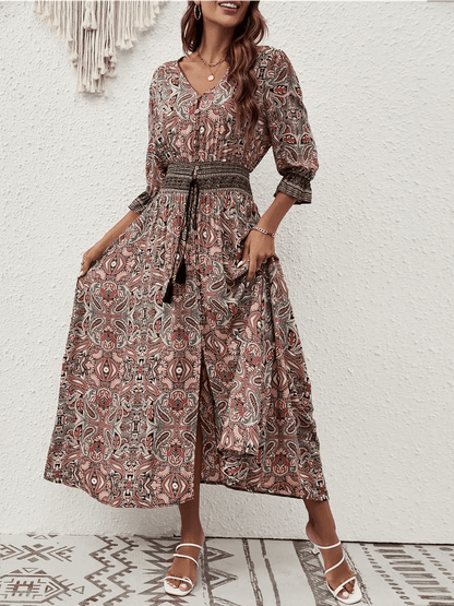 Woman in Amber Muse Maxi Dress featuring a paisley print and smocked waistband, perfect for summer boho style.