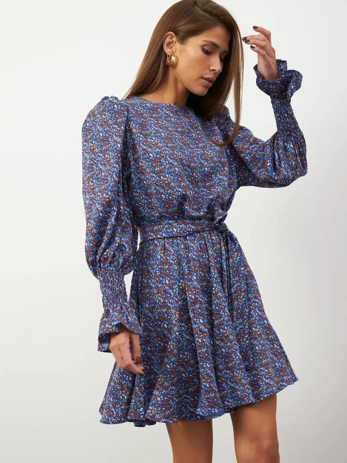Azure Bloom Mini Dress with blue floral patterns, long sleeves, and ruffled cuffs, exuding effortless elegance.