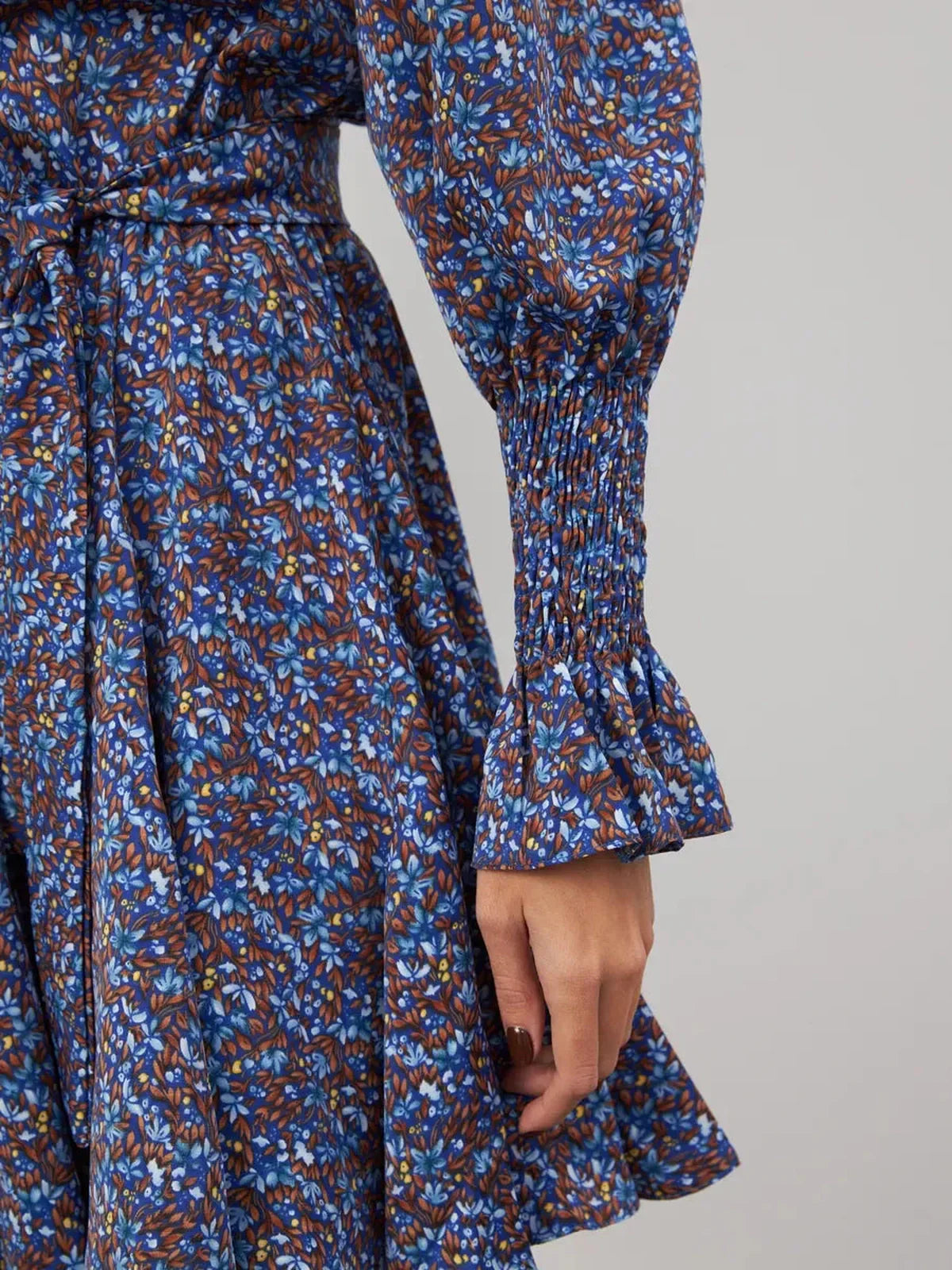 Azure Bloom Mini Dress detail showcasing vibrant blue floral patterns and elegant ruffled cuffs.